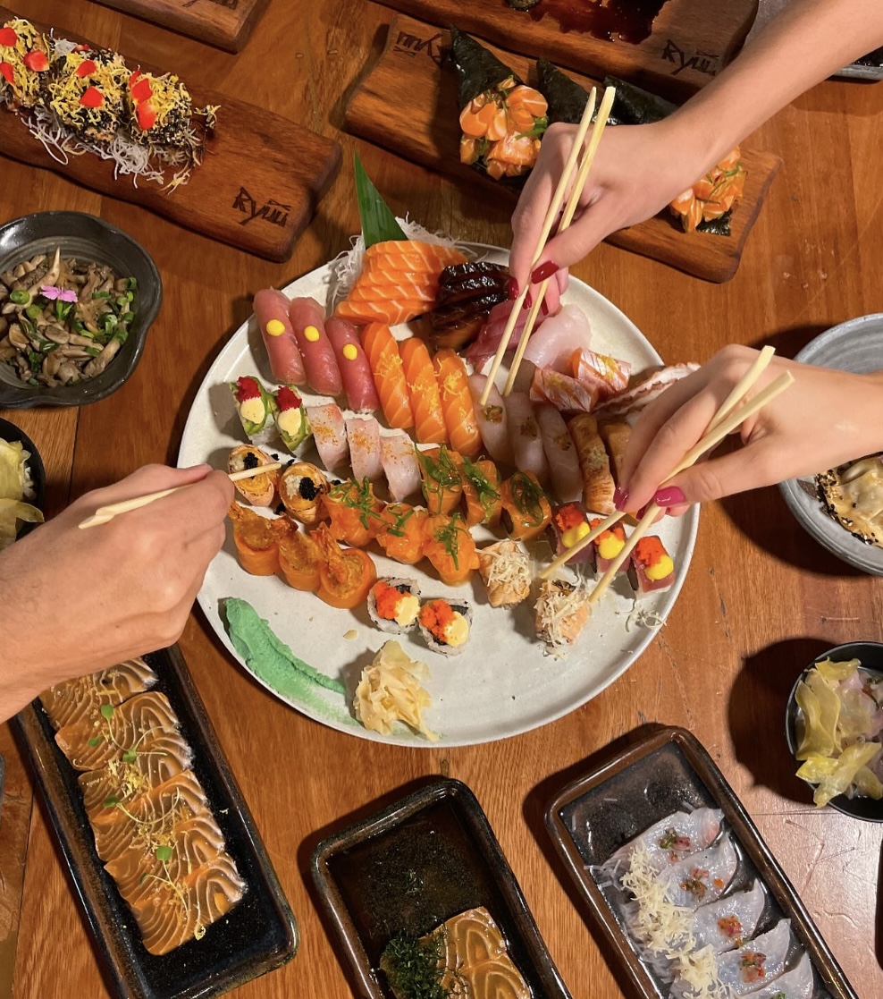 Mesa com sushis, sashimis e pratos compartilhados no Ryuu