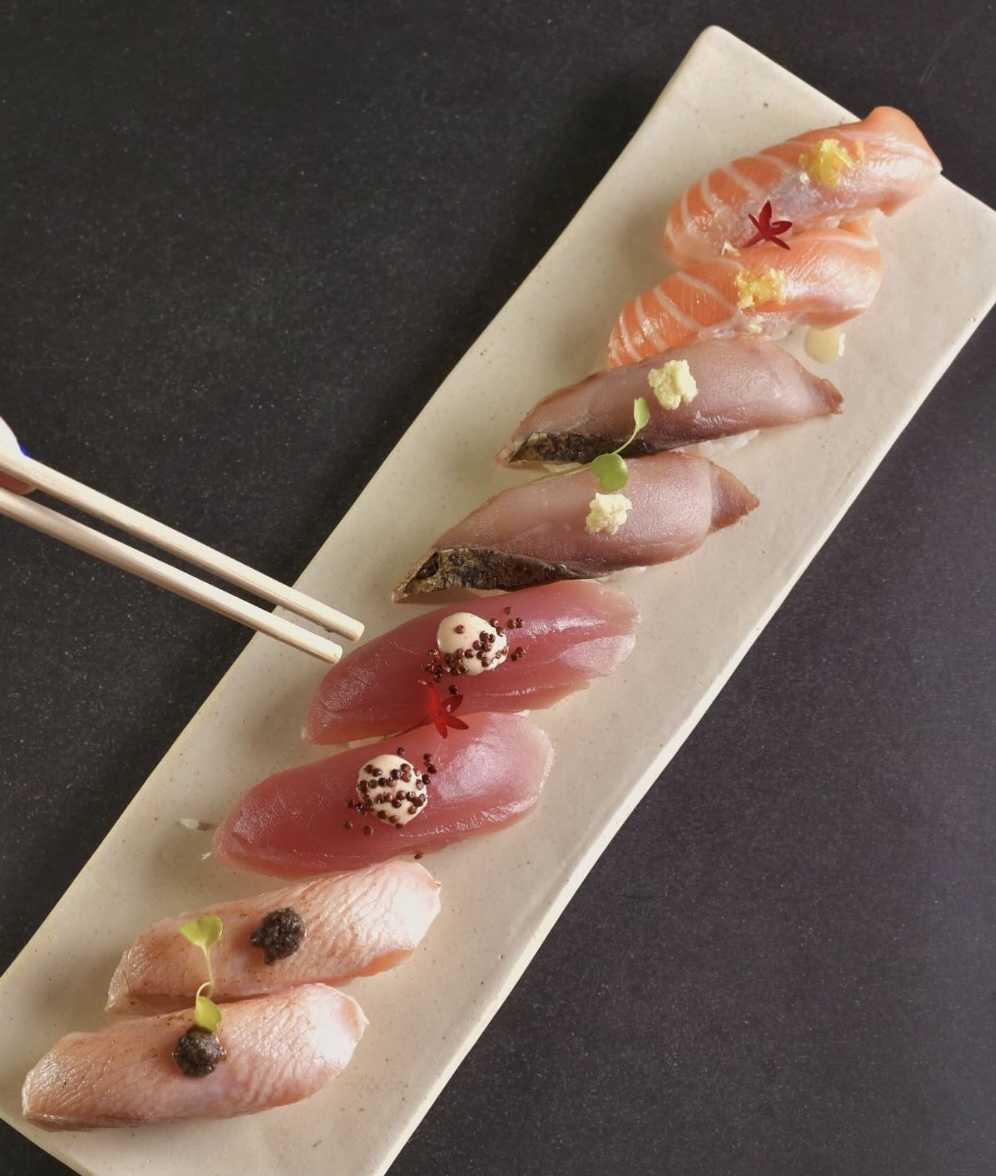 Nigiris de salmão, atum e peixe branco sobre prato de cerâmica
